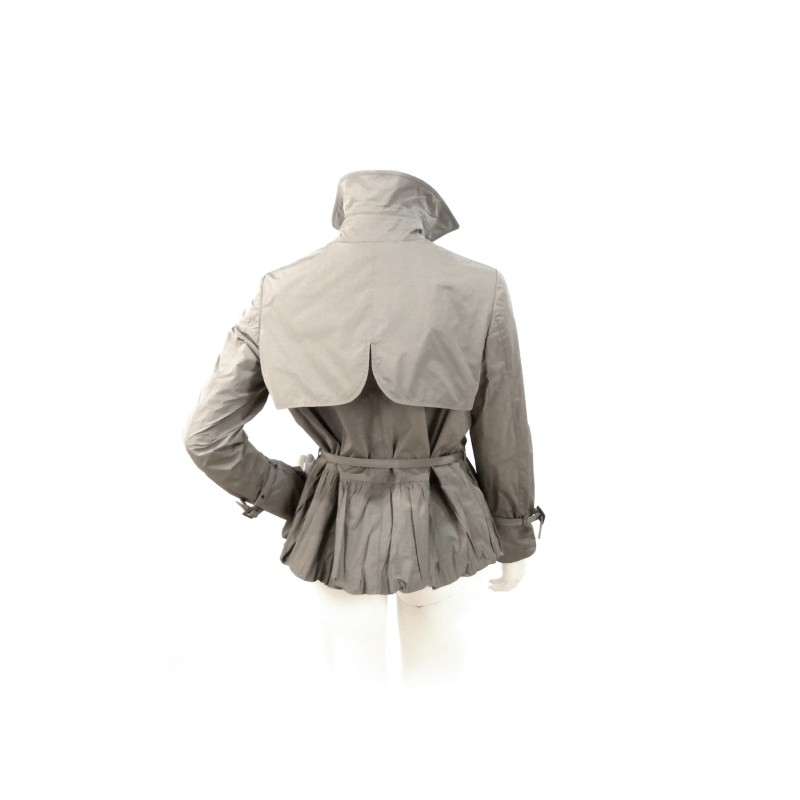 Short women's jacket with concealed buttons thin waist belt and front bow decoration.