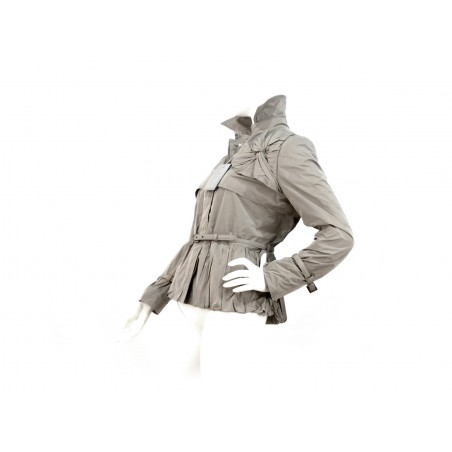 Short women's jacket with concealed buttons thin waist belt and front bow decoration.