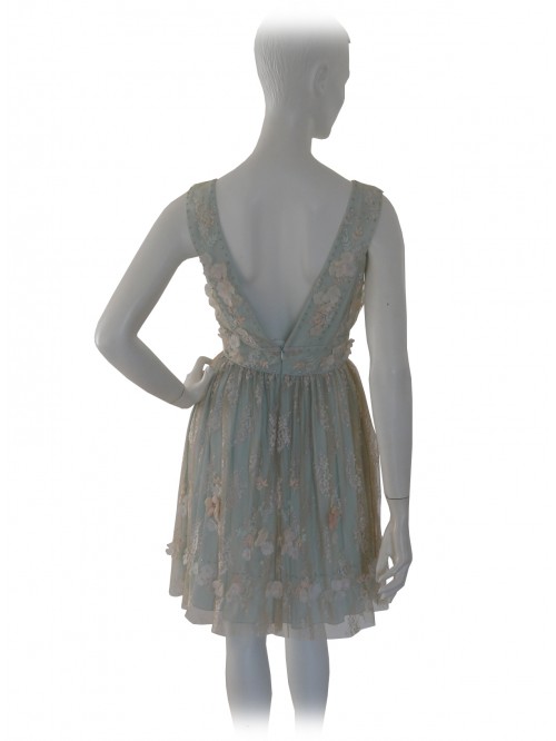 Elegant woman dress, lace with flowers applied ecru on green