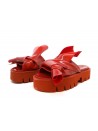 Woman sandals with wedge, glossy effect with asymmetrical knot decoration.