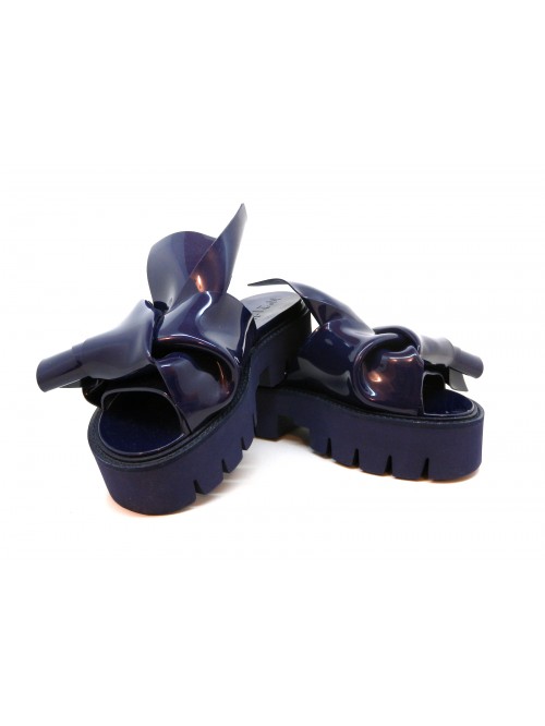 Sandali Donna con zeppa, effetto glossy con decoro nodo asimmetrico.