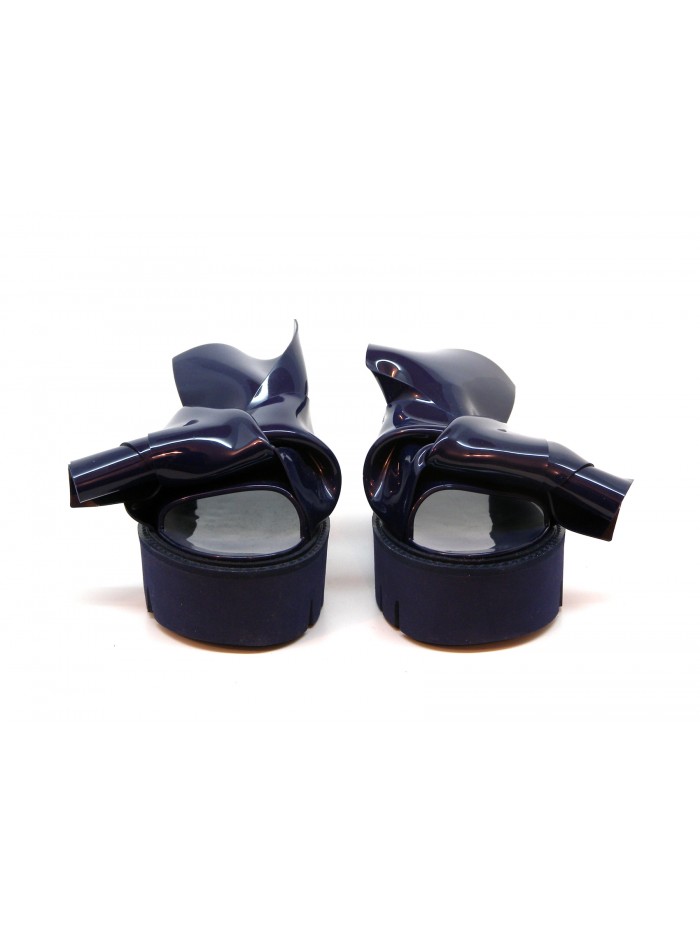Woman sandals with wedge, glossy effect with asymmetrical knot decoration.