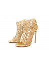 Women's sandals with 130mm heel with wrap-around net on gold color.